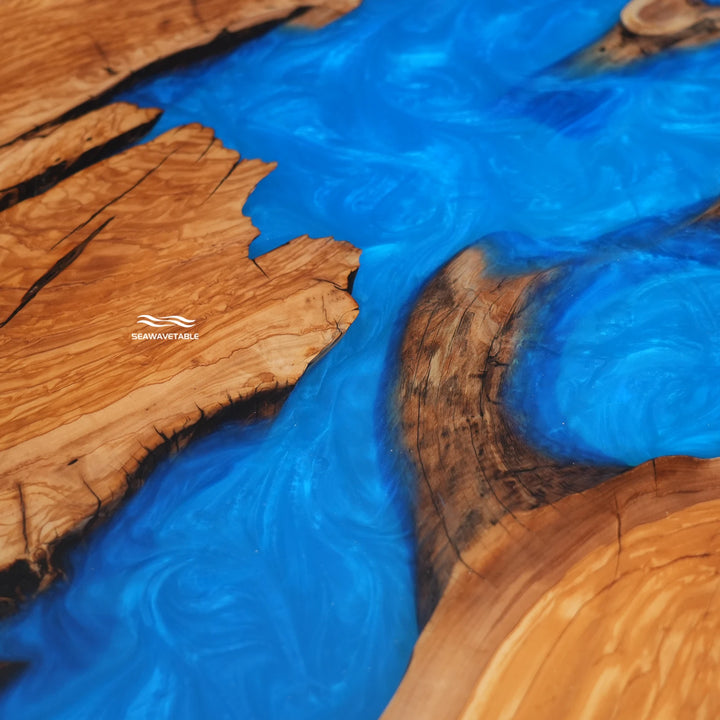 Custom olive wood dining table with swirling blue resin centerpiece
