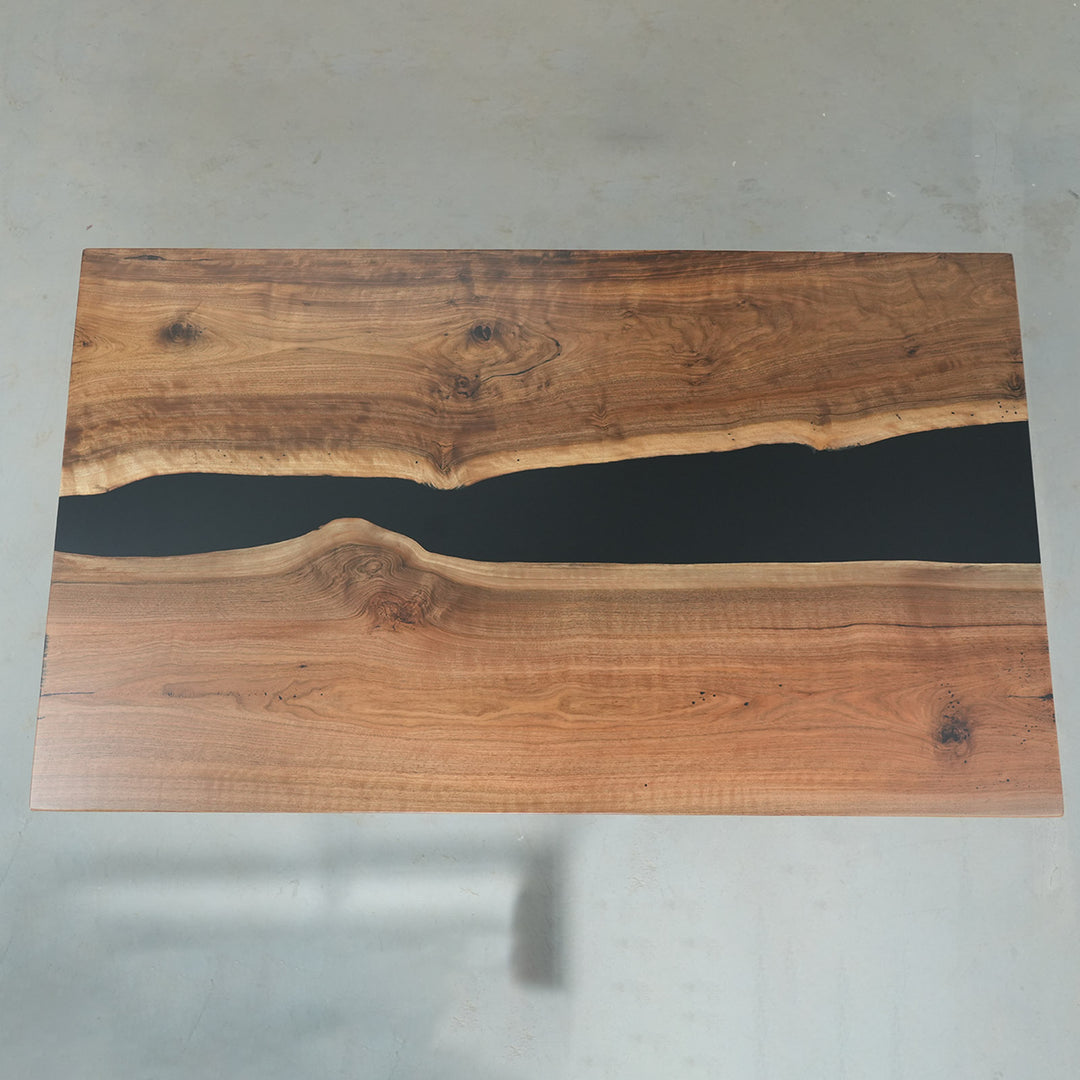 Natural walnut wood slab table with glossy black epoxy channel