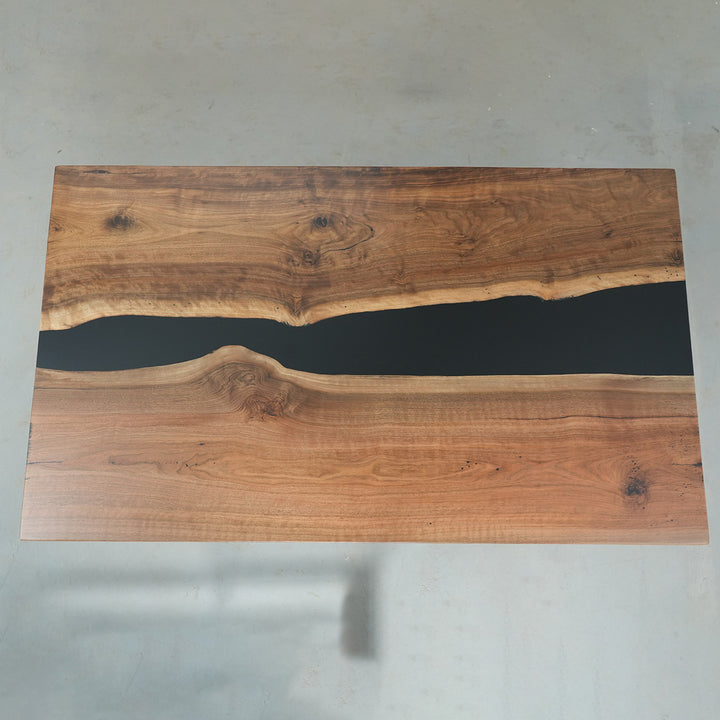 Natural walnut wood slab table with glossy black epoxy channel