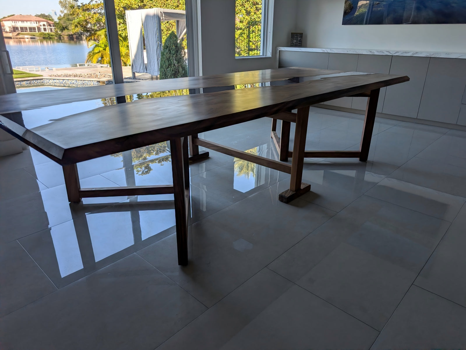 Wide-angle customer image showing the matte walnut banquet table with deep blue epoxy in a modern dining space.