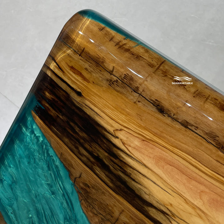 Olive wood dining table detail featuring transparent epoxy table resin filling and unique natural patterns, showcasing premium dining table craftsmanship - SeaWaveTable
