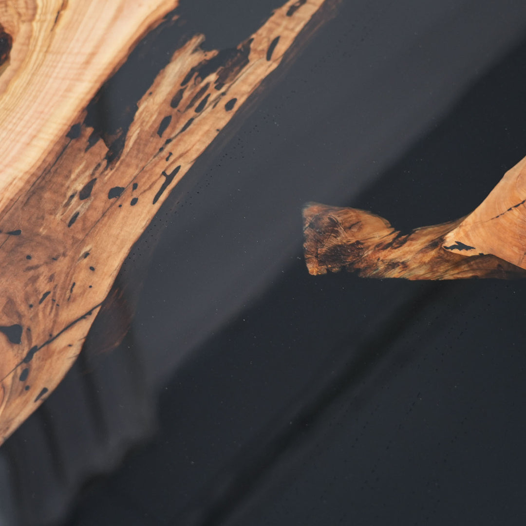 Handcrafted olive wood table featuring deep black resin