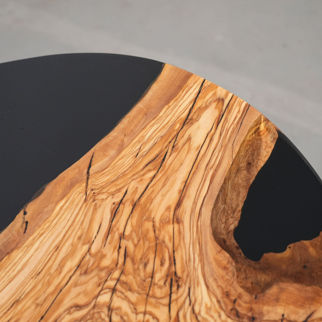 Artistic round table showing olive wood patterns and resin