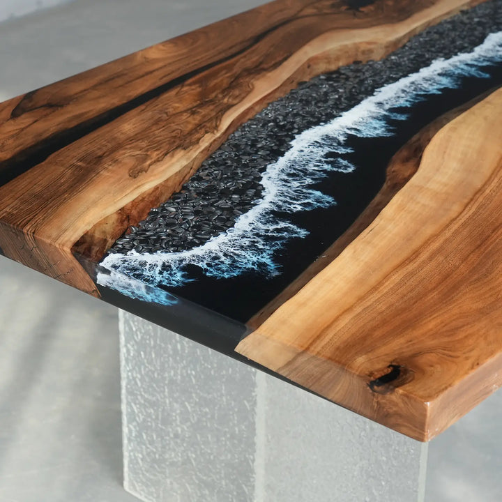 Custom black resin river table with textured pebble shoreline design