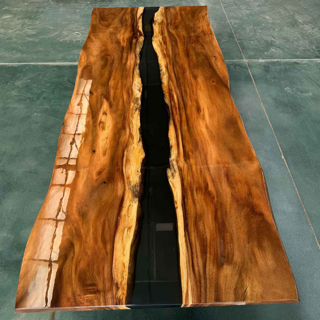 Large solid walnut river table with deep black epoxy resin for luxury dining rooms.
