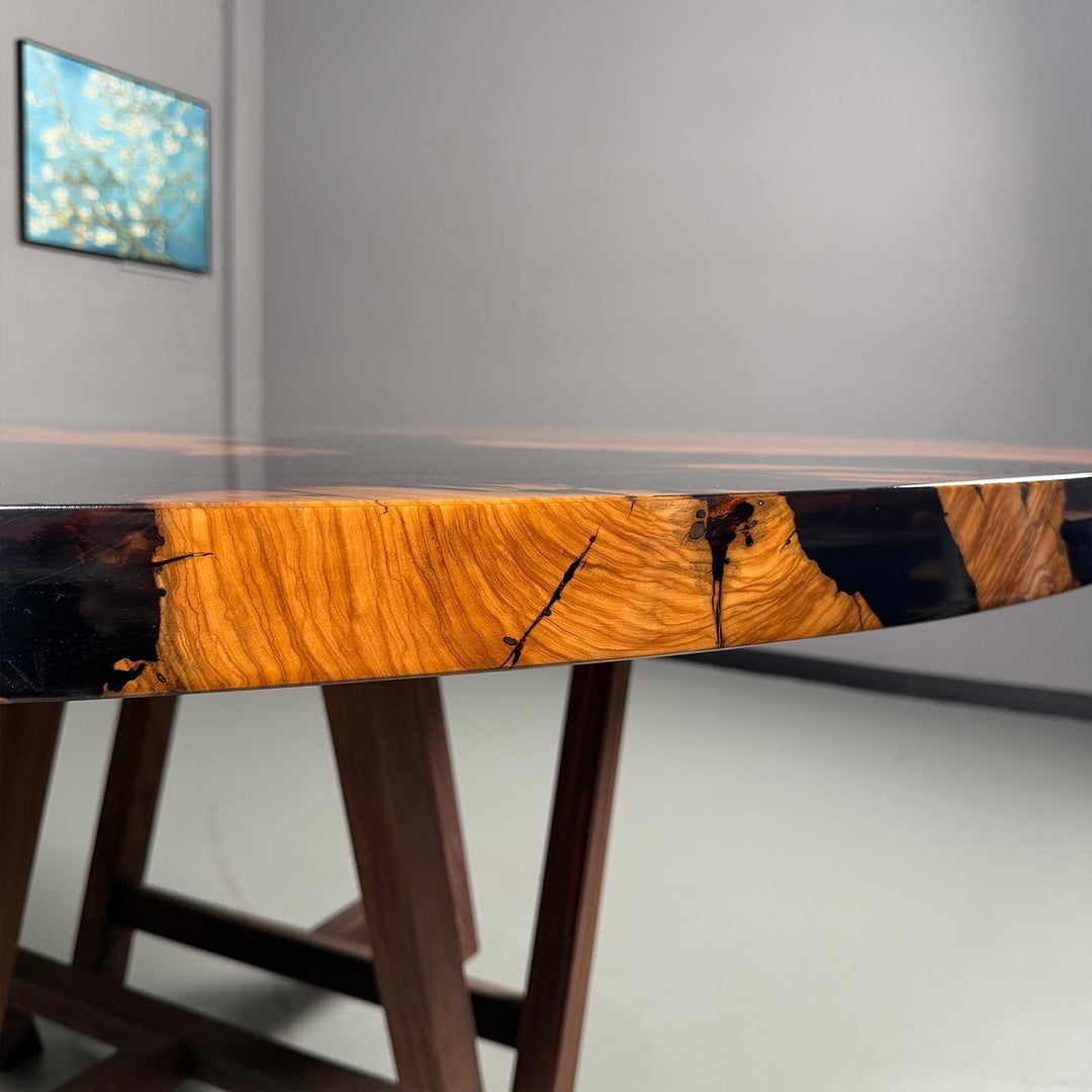 Conceptual view of the round table's surface, illustrating the "river irregular distribution" of the glossy black epoxy.