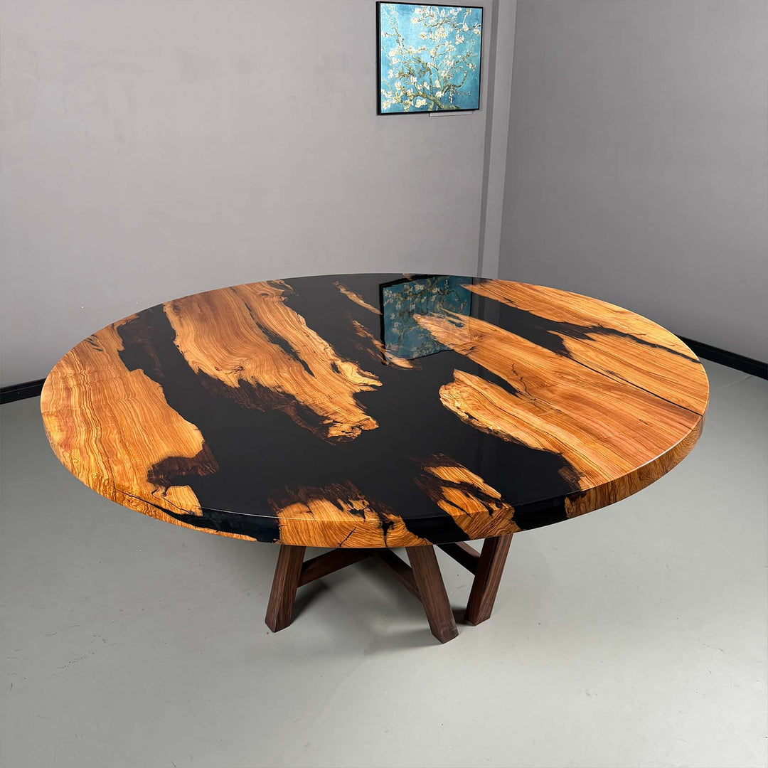 The full round olive wood table with a "Midnight Black" epoxy river, presented in a modern, industrial setting.