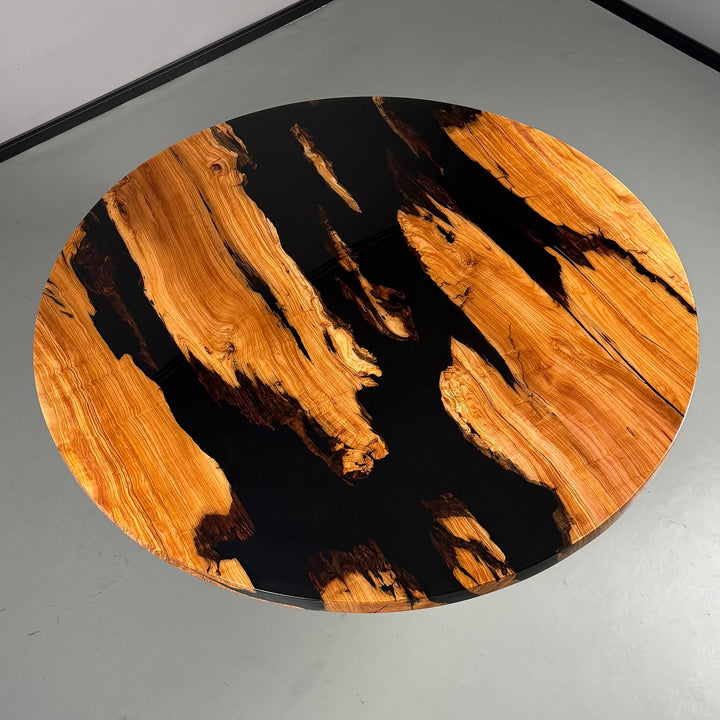 Top-down view of the 70-inch round olive wood and black epoxy resin dining table, highlighting the "river" design.