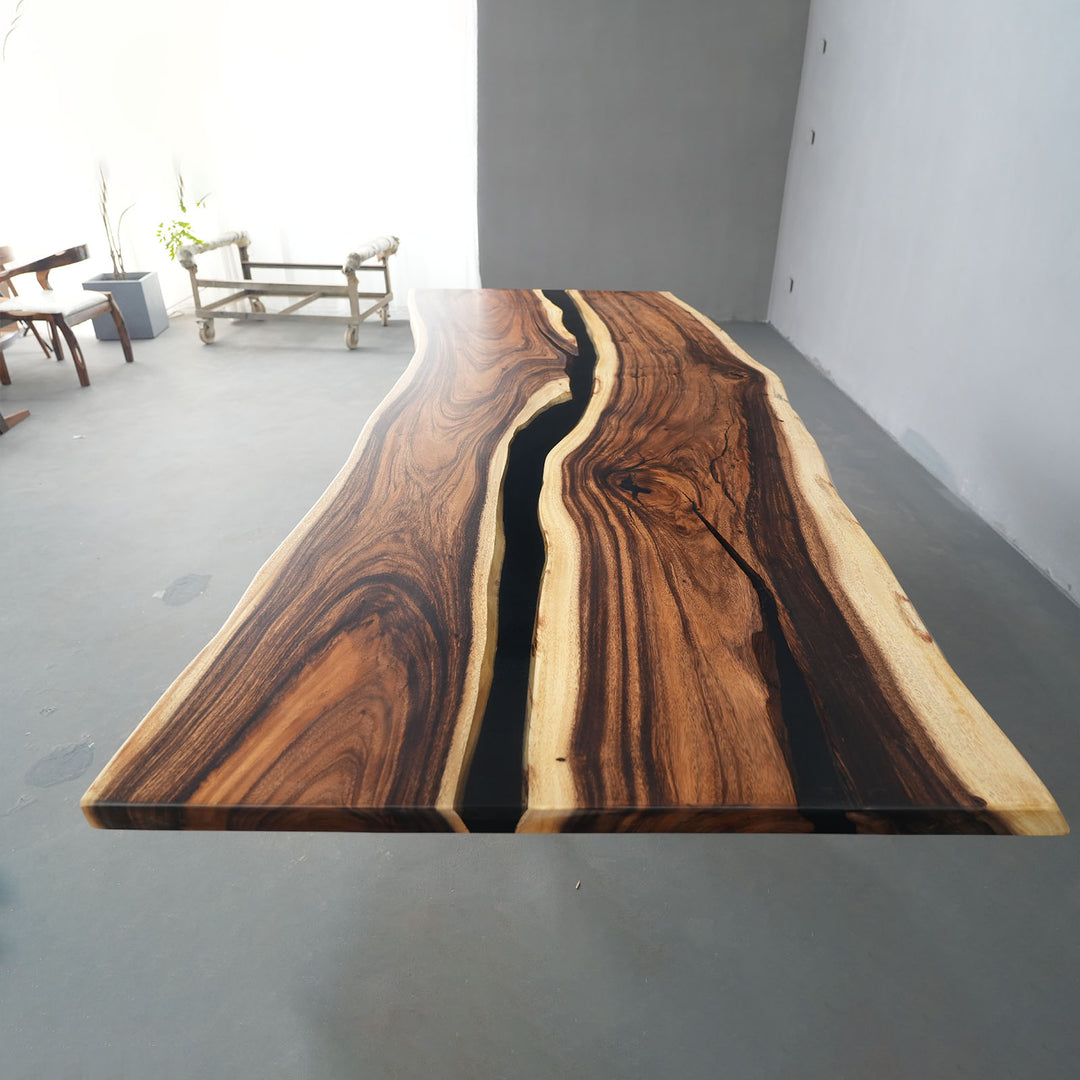 Modern walnut river table with black epoxy resin in open dining space