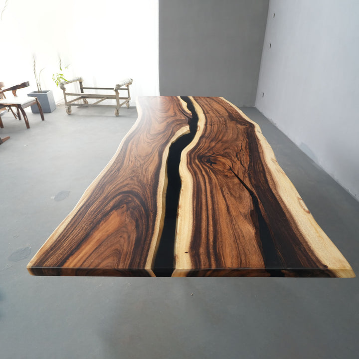 Modern walnut river table with black epoxy resin in open dining space