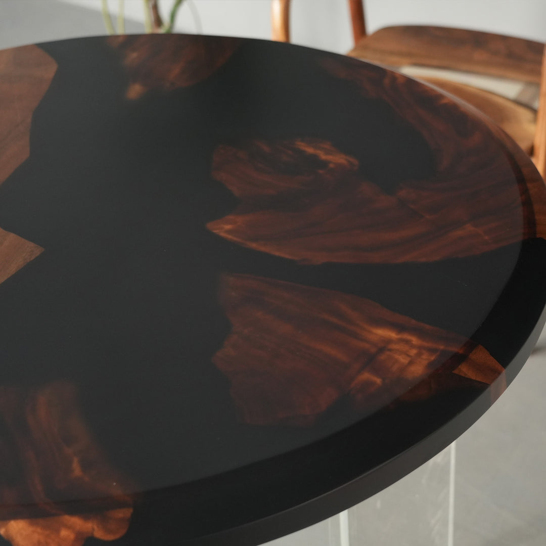 Circular walnut wood and deep black resin table with smooth surface