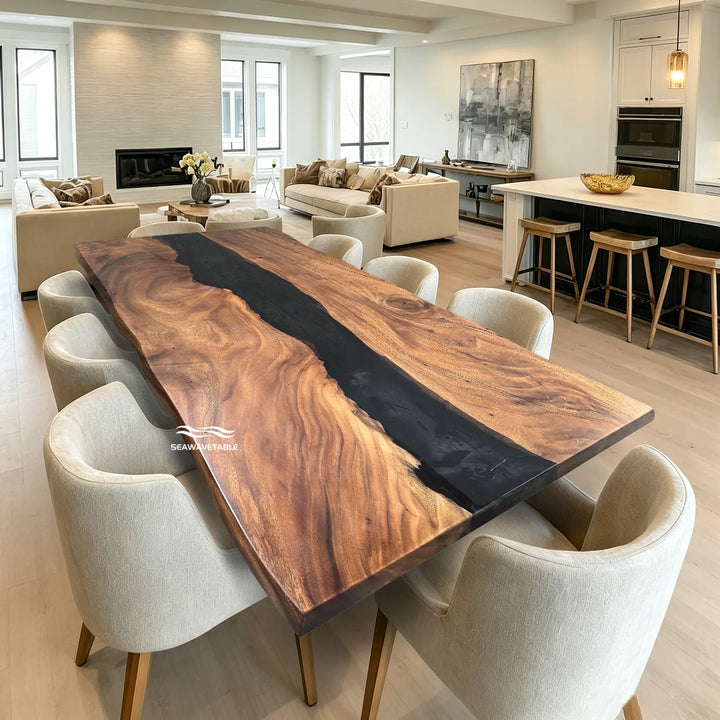 SeawaveTable-0A large rectangular live-edge wooden dining table with a dark river-rock style center channel, surrounded by upholstered dining chairs in a bright modern living room and kitchen setting.