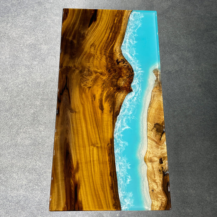 Epoxy resin ocean wave dining table made with live edge golden camphor wood in a modern dining room.