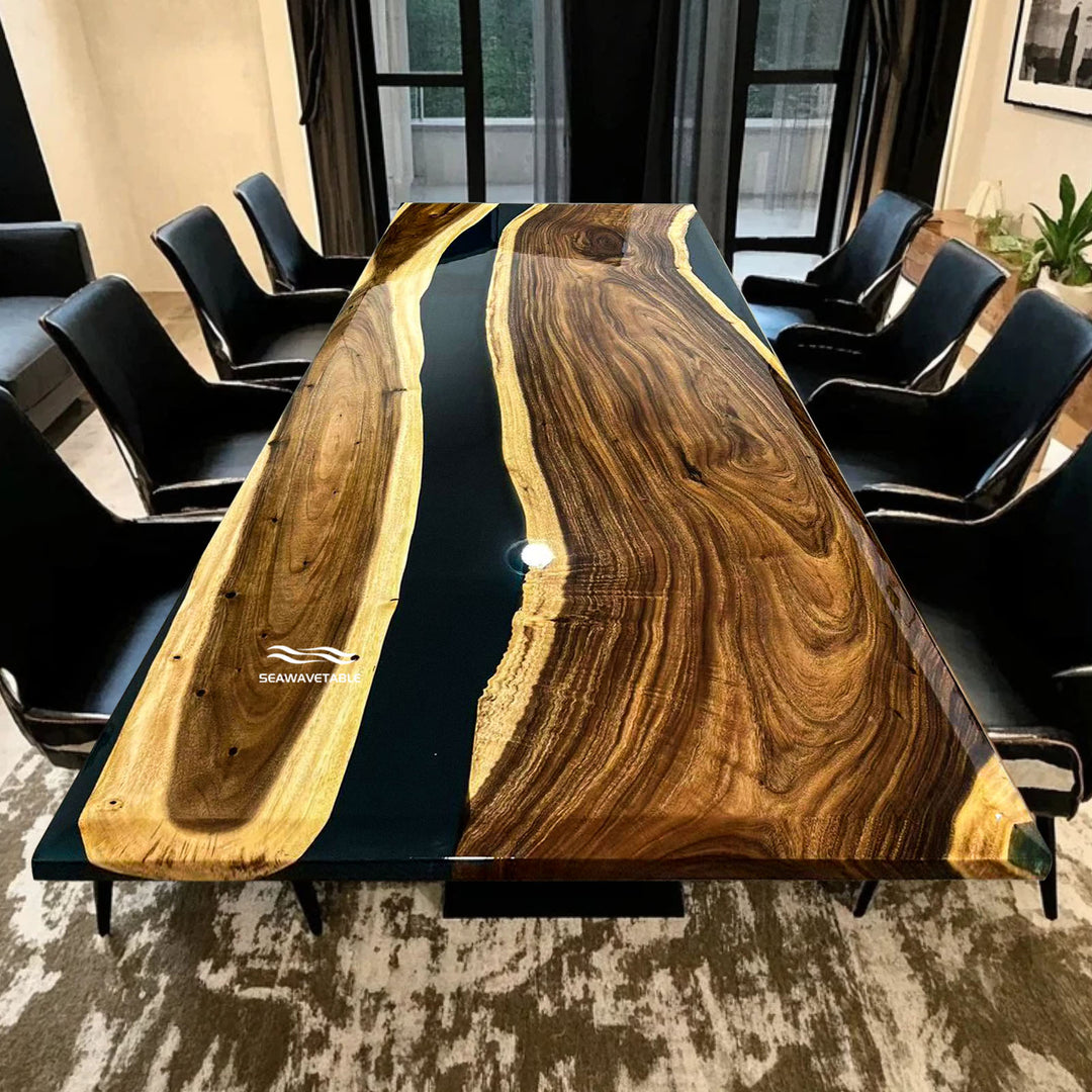 Seawavetable-Long wooden dining table with black resin finish in a room with chairs and decor.