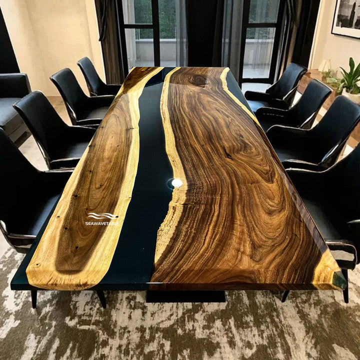 Seawavetable-Long wooden dining table with black resin finish in a room with chairs and decor.