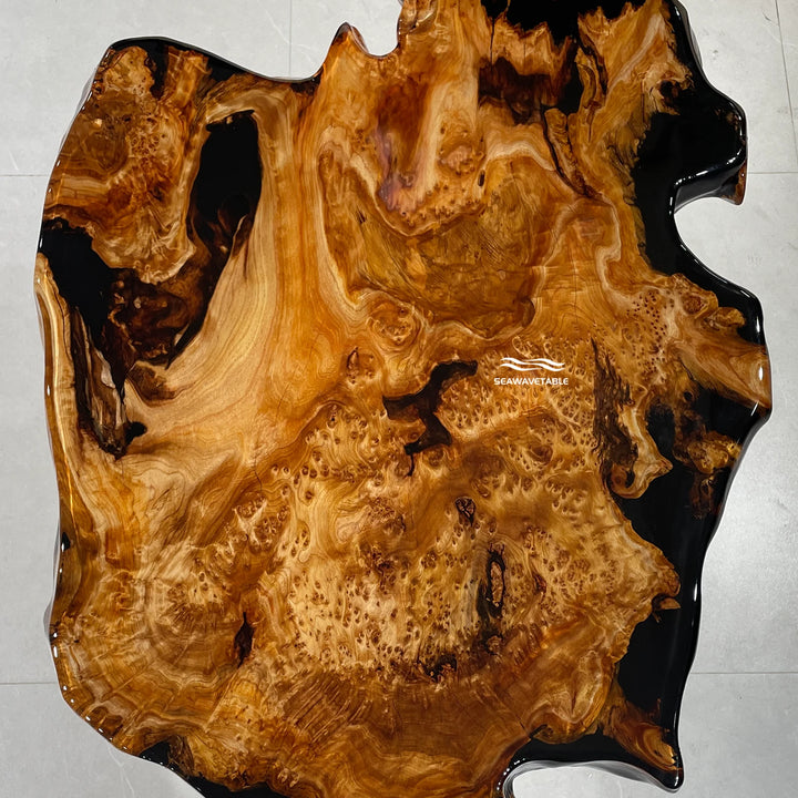 Close-up of a live-edge coffee table showing the organic edge contour where wood meets dark translucent resin - SeawaveTable
