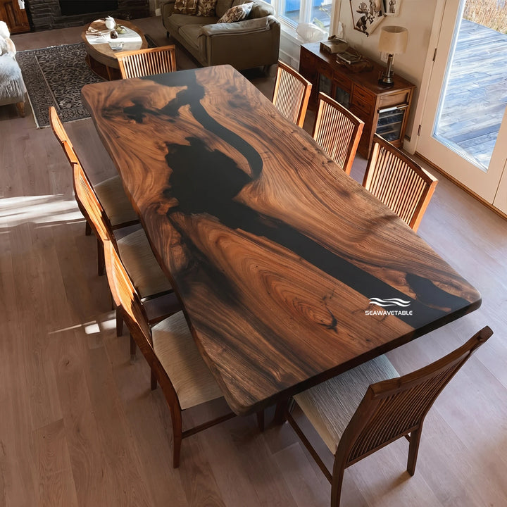A custom epoxy resin walnut dining table featuring a flowing black river inlay and live-edge design, placed in a bright contemporary dining area with wood chairs and warm interior decor - SeawaveTable
