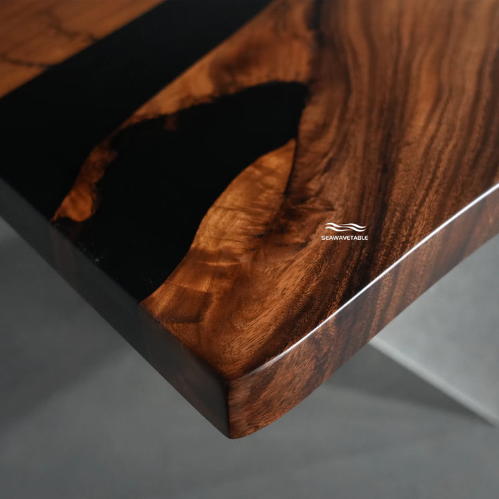 Close-up of a live-edge dining table showing the organic edge contour where the walnut meets the black epoxy resin - SeawaveTable