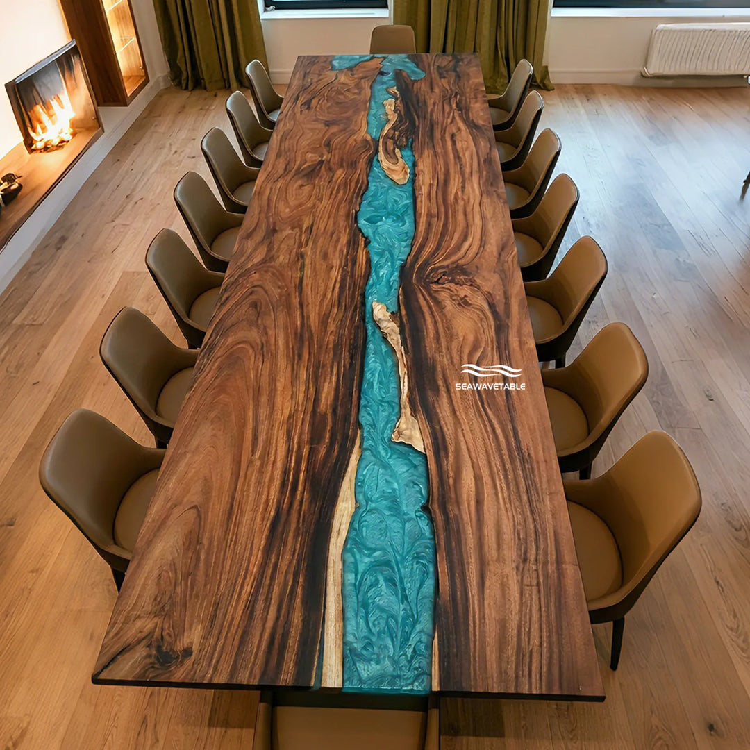 A long rectangular wooden dining table with a vivid turquoise river-like inlay running down the center, surrounded by brown upholstered chairs in a modern room with wood floors and a fireplace.