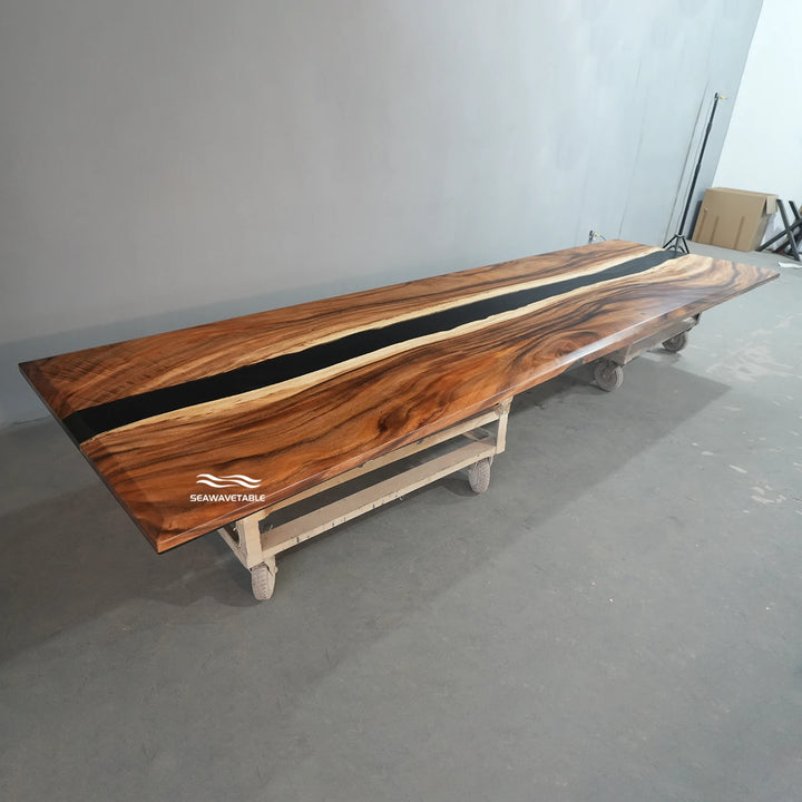 A wood conference table display featuring walnut slab with black resin inlay, showcased in a bright studio setting for corporate interior design presentation - SeawaveTable