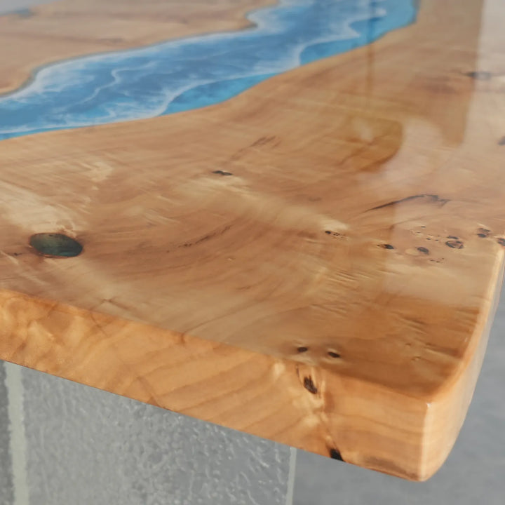 Close-up of a live-edge dining table showing the organic edge contour where the poplar meets the vivid blue resin - SeawaveTable