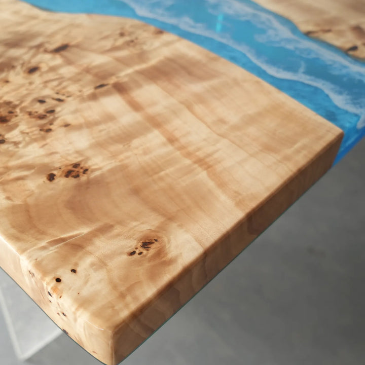 Surface detail of a custom epoxy table capturing the striking contrast between the warm poplar wood and the brilliant blue resin ocean - SeawaveTable