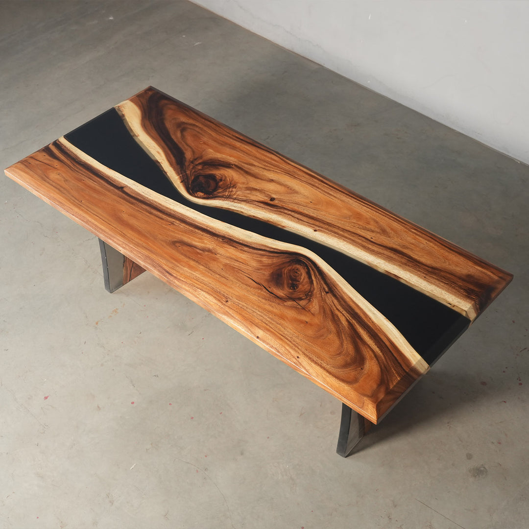 Exhibition view of a custom epoxy dining table with walnut wood and flowing black resin, displayed in a modern furniture gallery or design showroom - SeawaveTable