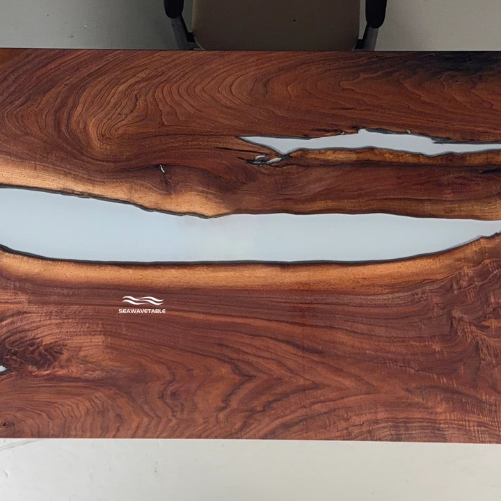 Close-up of a live-edge dining table showing the organic edge contour where the black walnut meets the white resin river - SeawaveTable