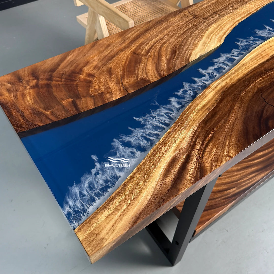 Close-up detail of a resin table showing the translucent blue river flowing through the solid walnut top surface - SeawaveTable