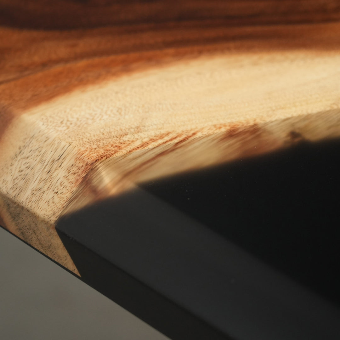 Close-up of a beveled-edge dining table showing the organic edge contour where the walnut meets the glossy black resin - SeawaveTable