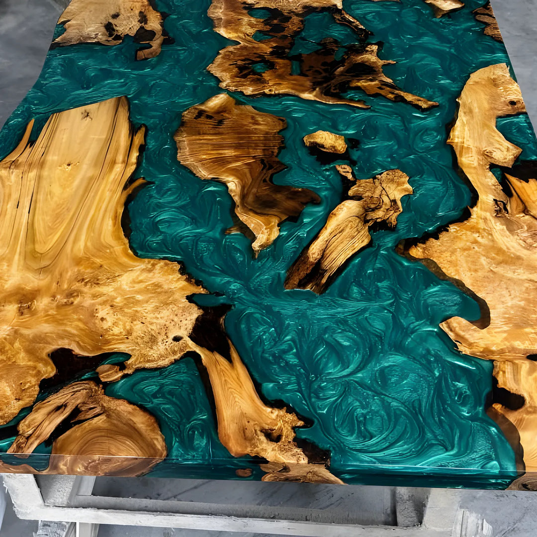 Seawavetable-A live-edge wooden table featuring a resin top design where the continents are carved from natural wood and the surrounding oceans are filled with swirling teal resin.