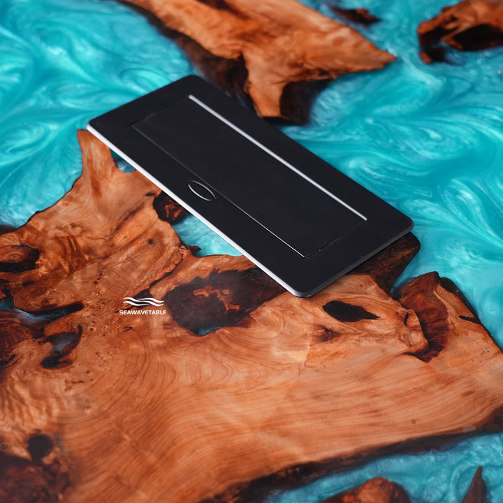Close-up view of a Cunninghamia epoxy table featuring a glossy wood table top with power integration - SeaWaveTable
