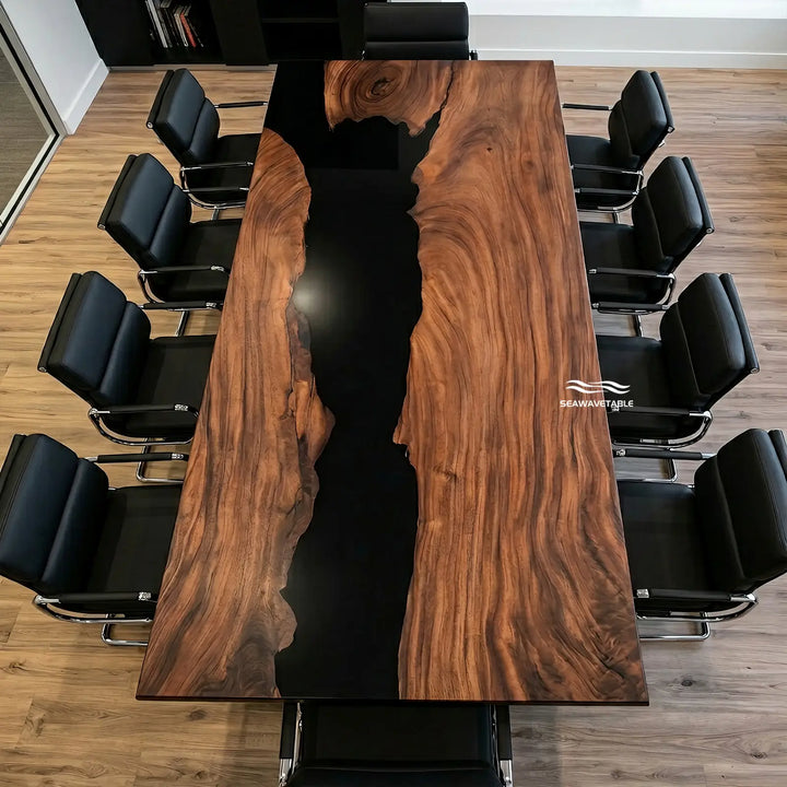 A rectangular wooden conference table with a glossy black resin river running down the center, surrounded by black office chairs on a wood floor. The brand name 'seaowright' is visible as a watermark on the right side of the table.