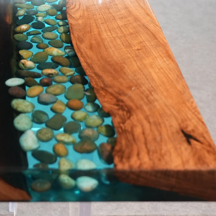 Seawavetable-macro shot stone details inside transparent blue resin river console table