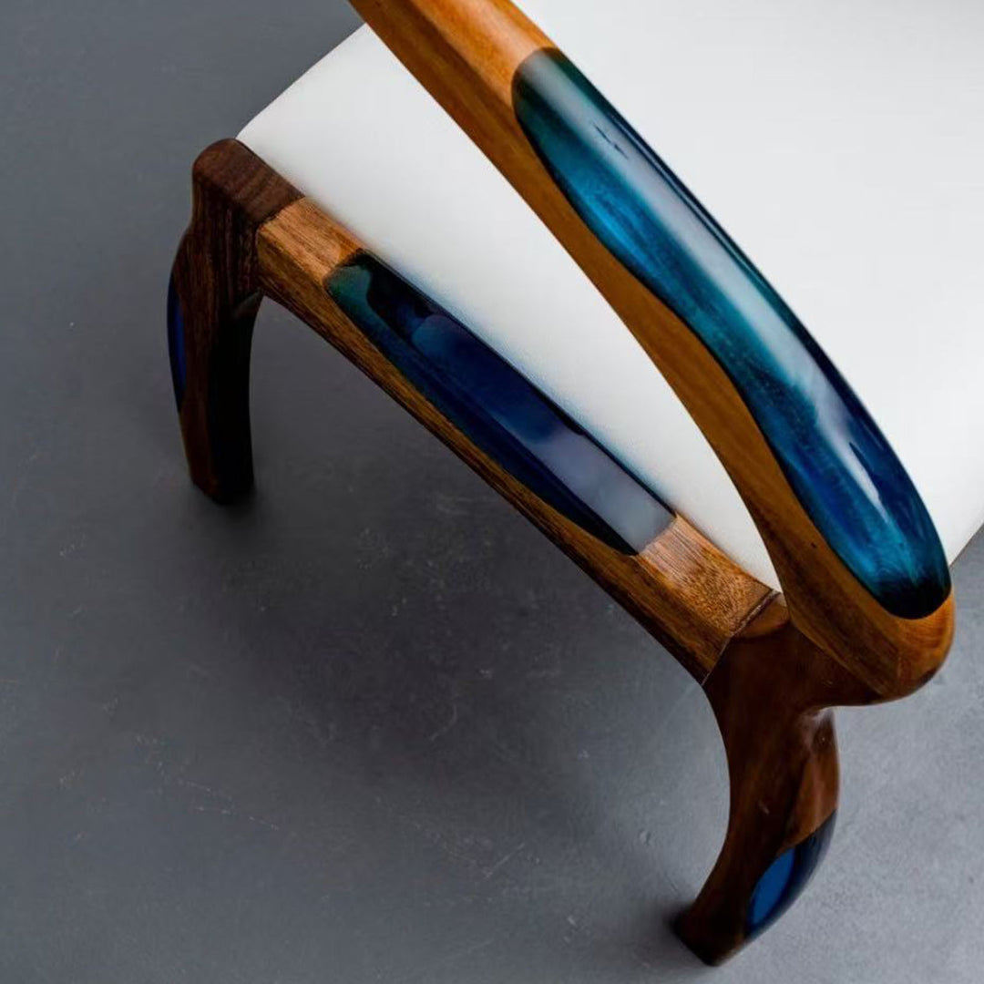 Modern accent chair made from solid wood with blue resin highlights