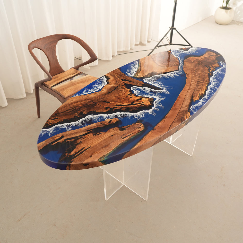 Seawavetable
Custom oval resin river table featuring deep blue and white wave patterns, surrounded by black dining chairs.