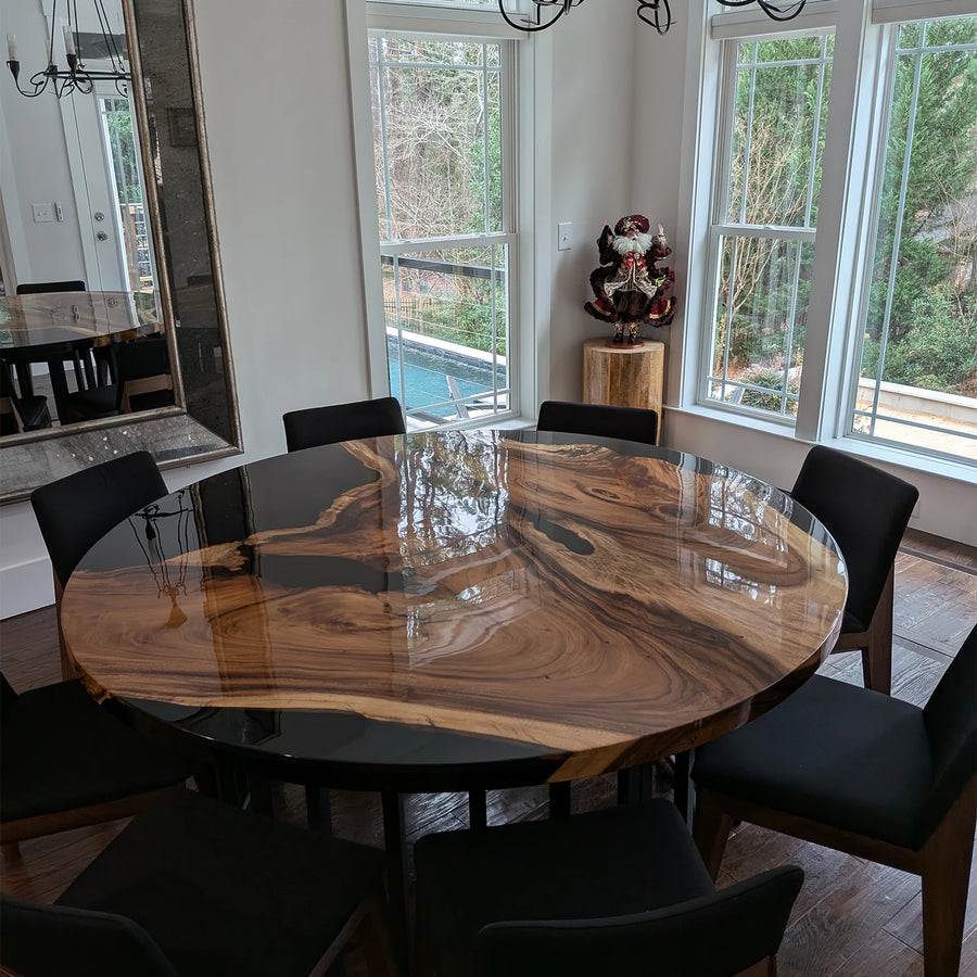 Round walnut resin table with black epoxy and natural grain in modern dining room