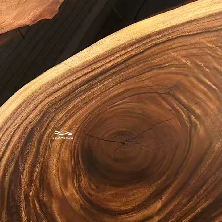 Seawavetable-Close-up of a large natural wood slab with prominent concentric growth rings and a visible branch scar, showing rich warm brown and tan tones.