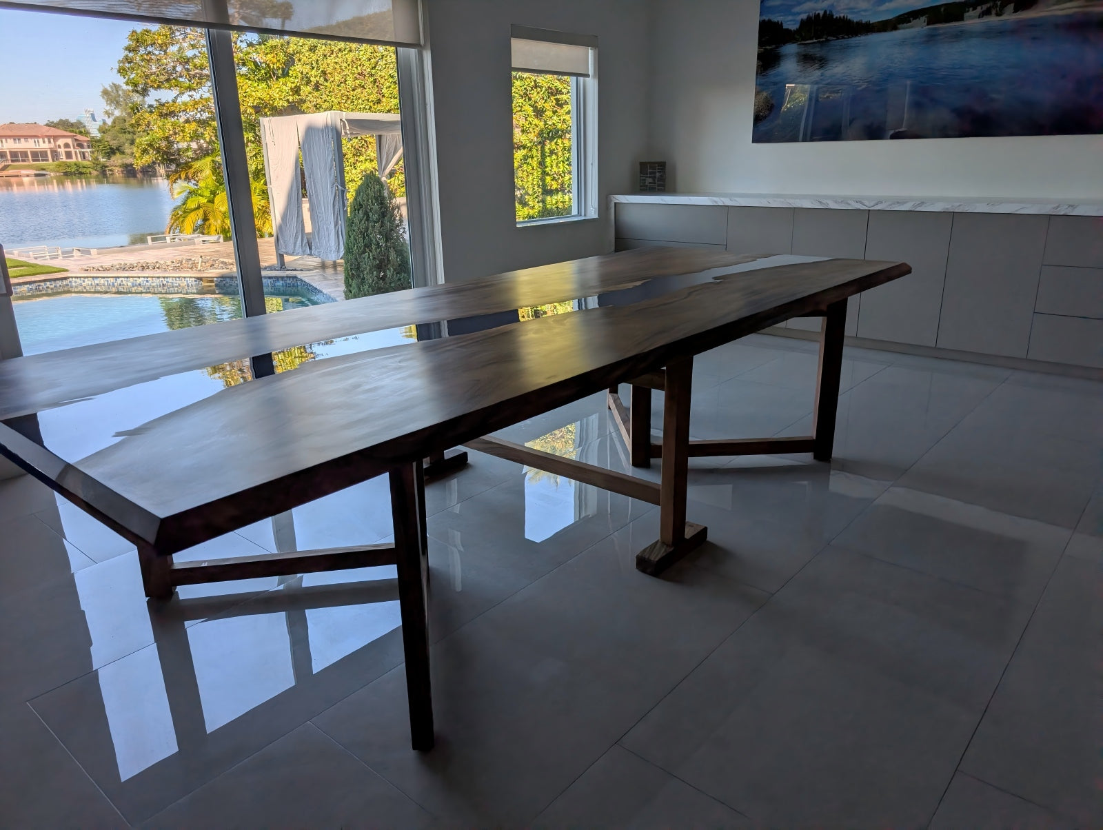 Steven’s home setup with the custom walnut and ocean-blue epoxy dining table placed as the room centerpiece.