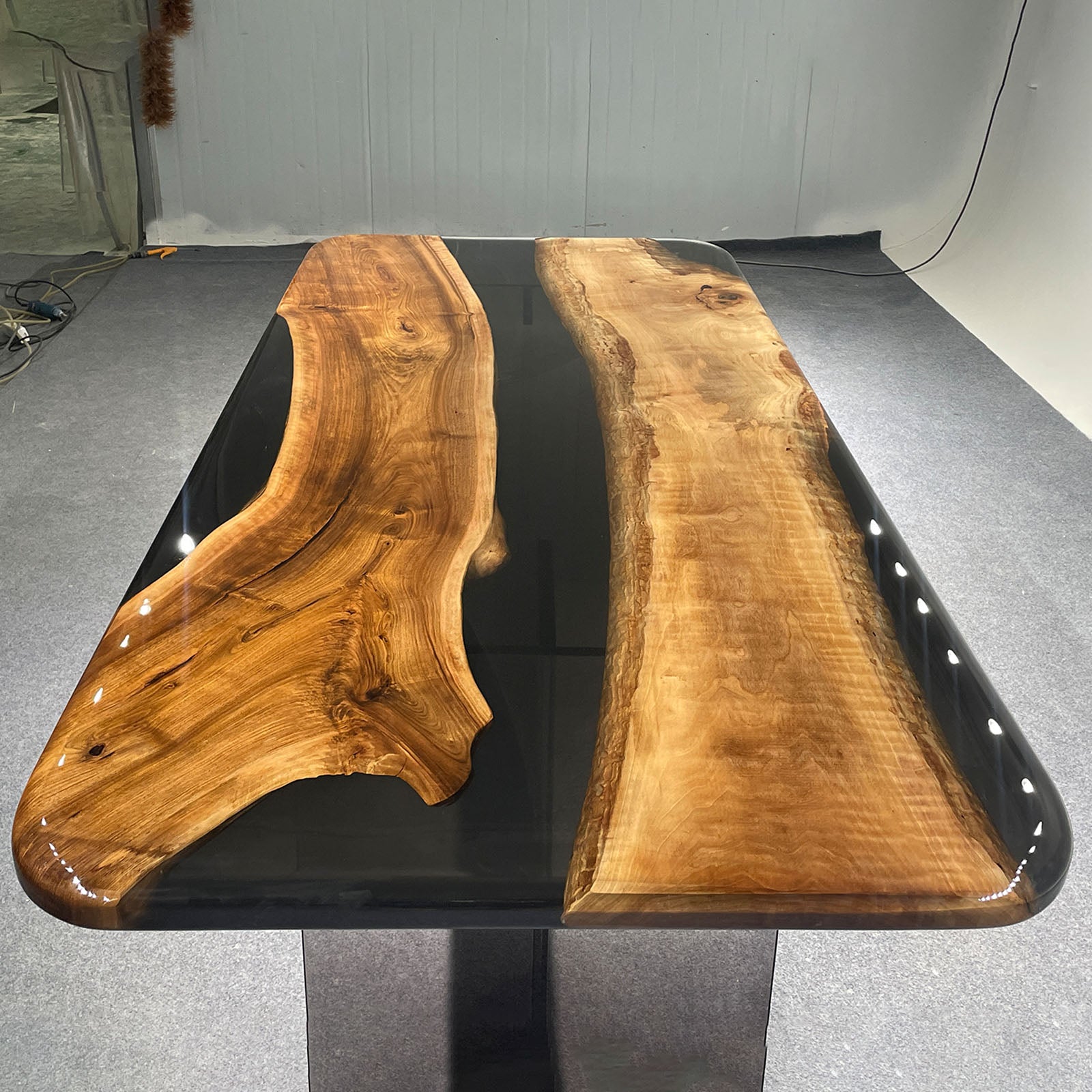 Black walnut black epoxy dining table styled in a modern dining room with minimalist décor