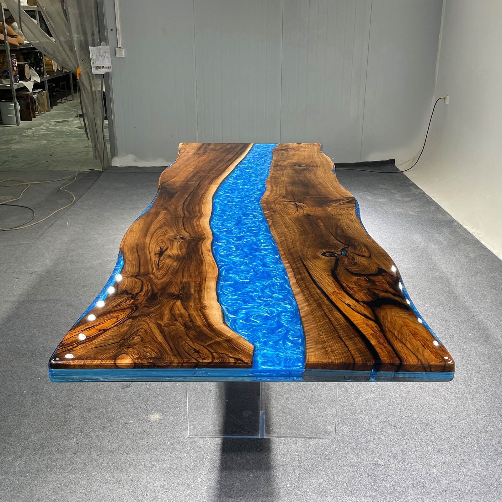 Handcrafted black walnut coffee table featuring deep ocean blue epoxy waves, perfect for modern interiors.