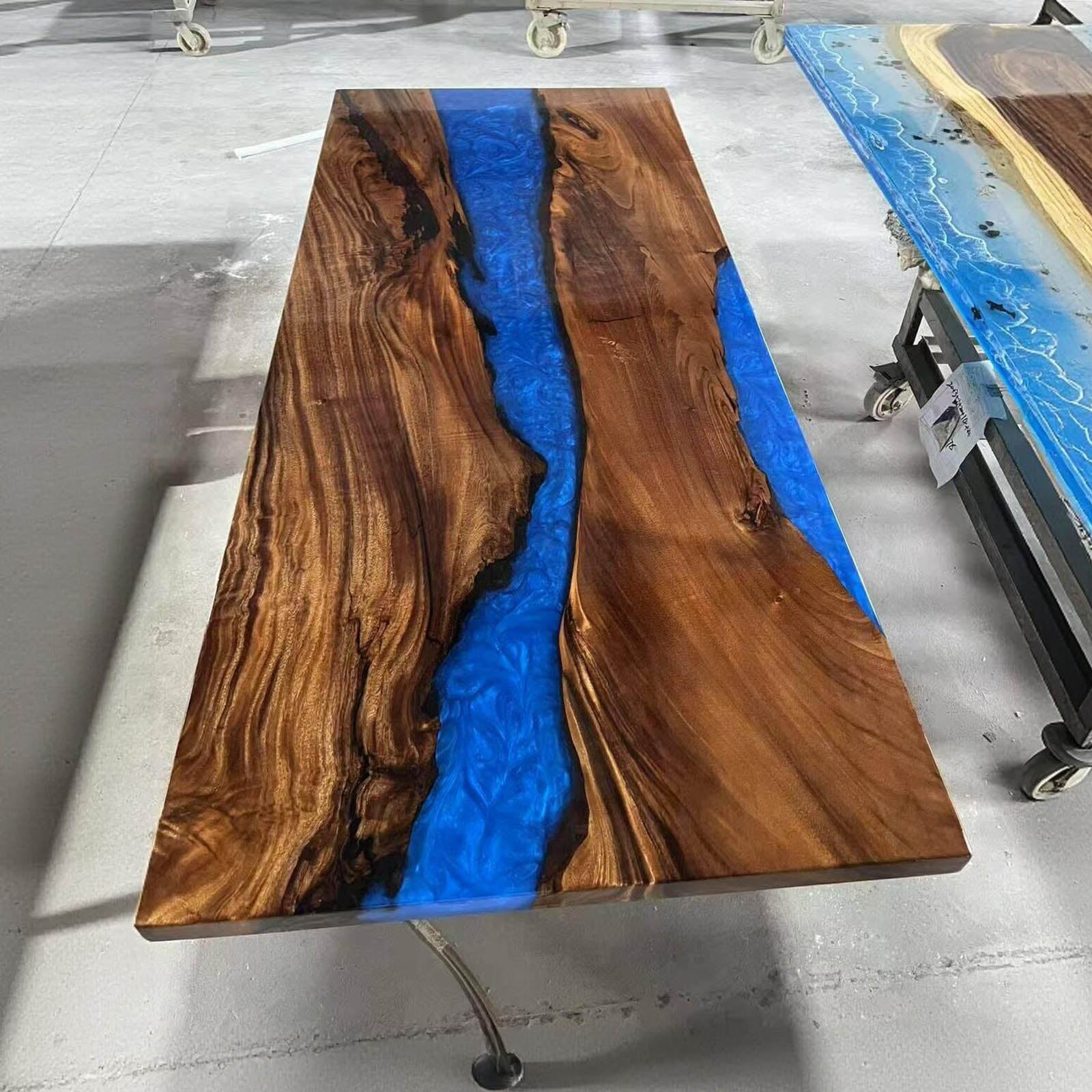 Detailed edge view of black walnut epoxy resin table showing smooth ocean blue flow and matte wood finish.