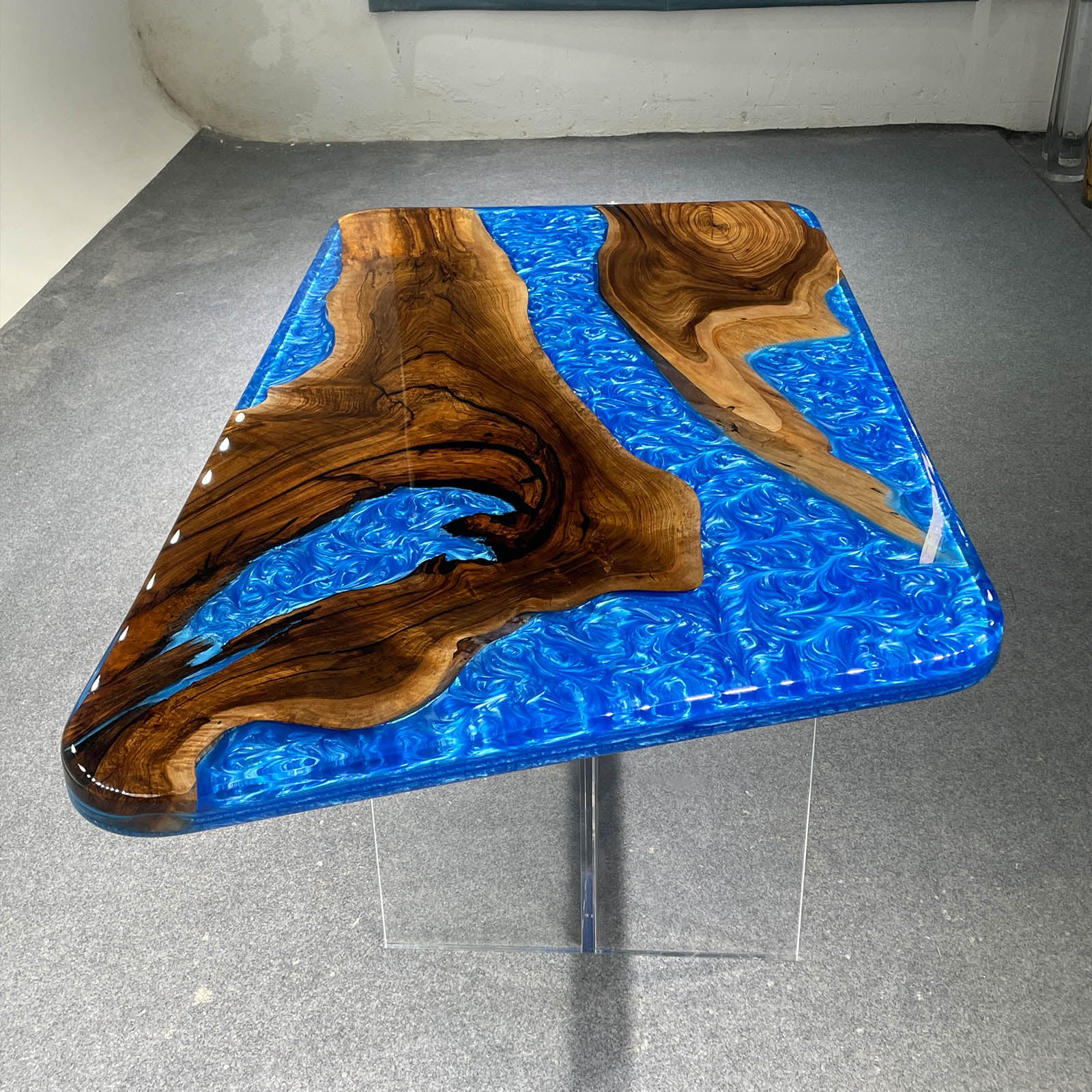 Live edge black walnut epoxy table with artistic blue resin design, handcrafted by skilled artisans.