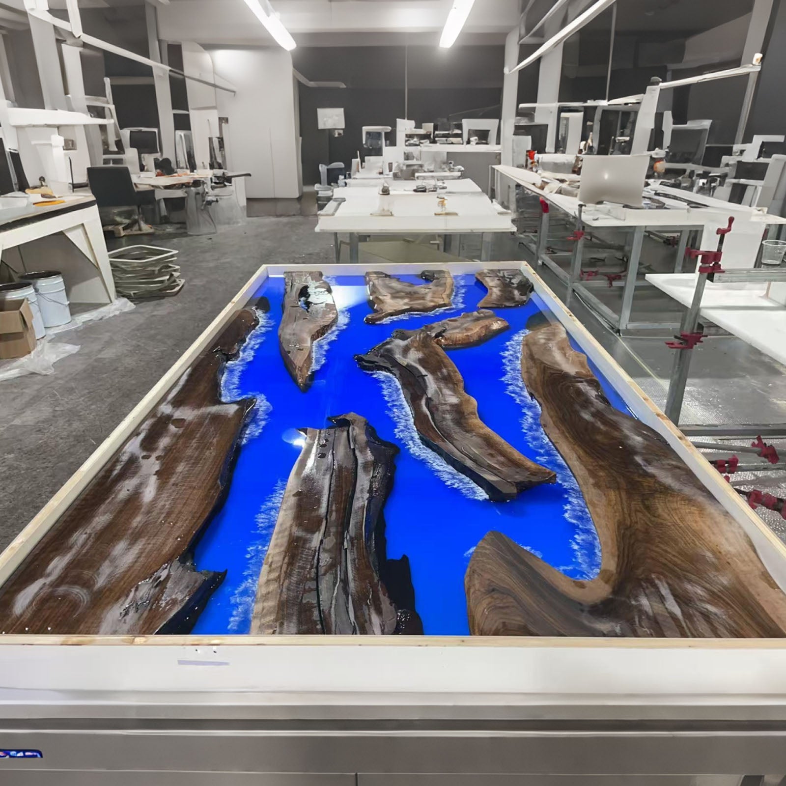 Pouring deep blue and white resin into black walnut table, custom epoxy process