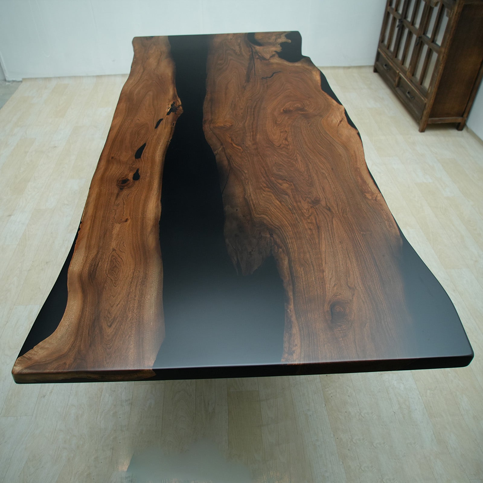 Black walnut river table set as an office meeting table with straight edges and deep black epoxy