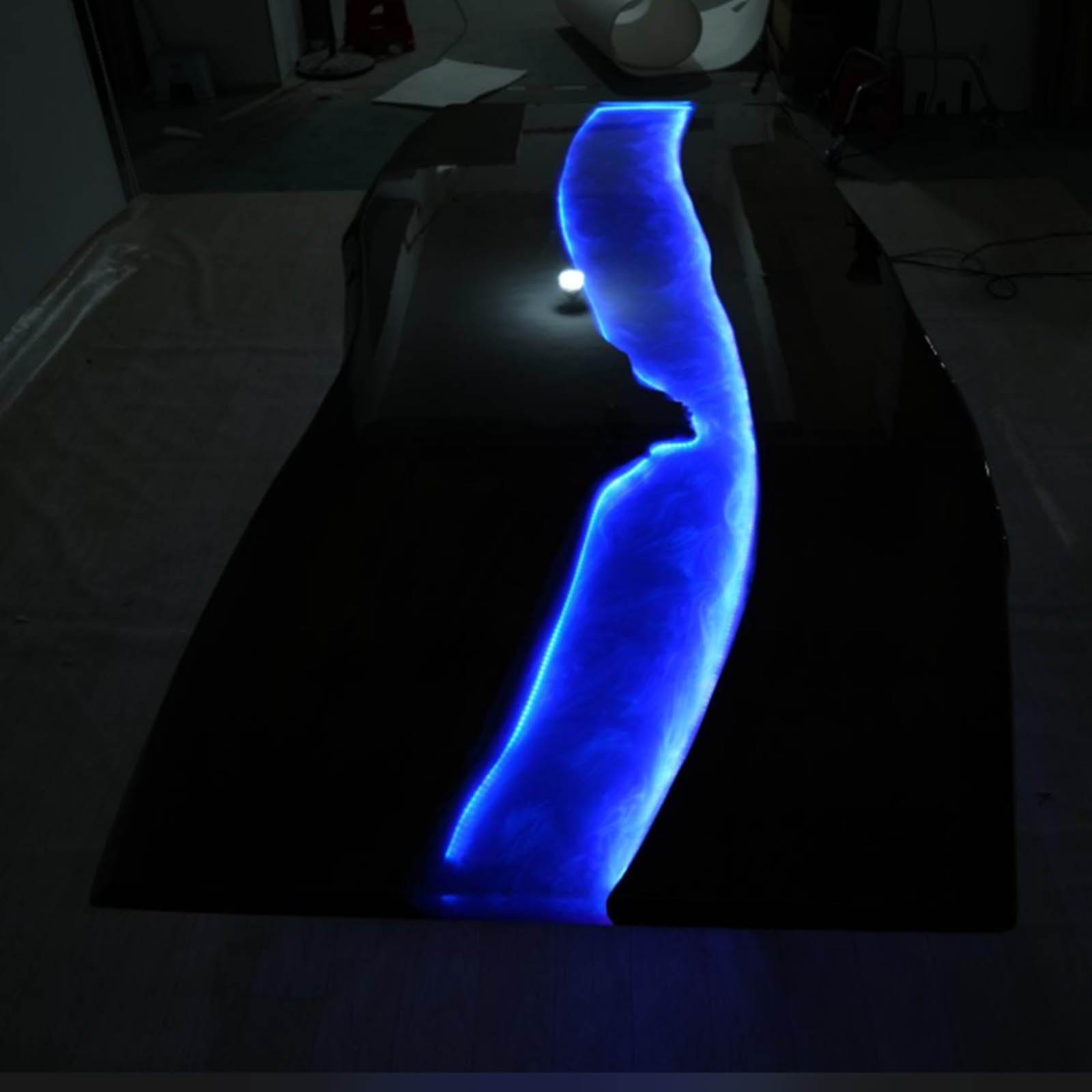 Multi-purpose black walnut live edge river table with swirling ocean blue resin and LED lighting, suitable for office workspace or dining room.