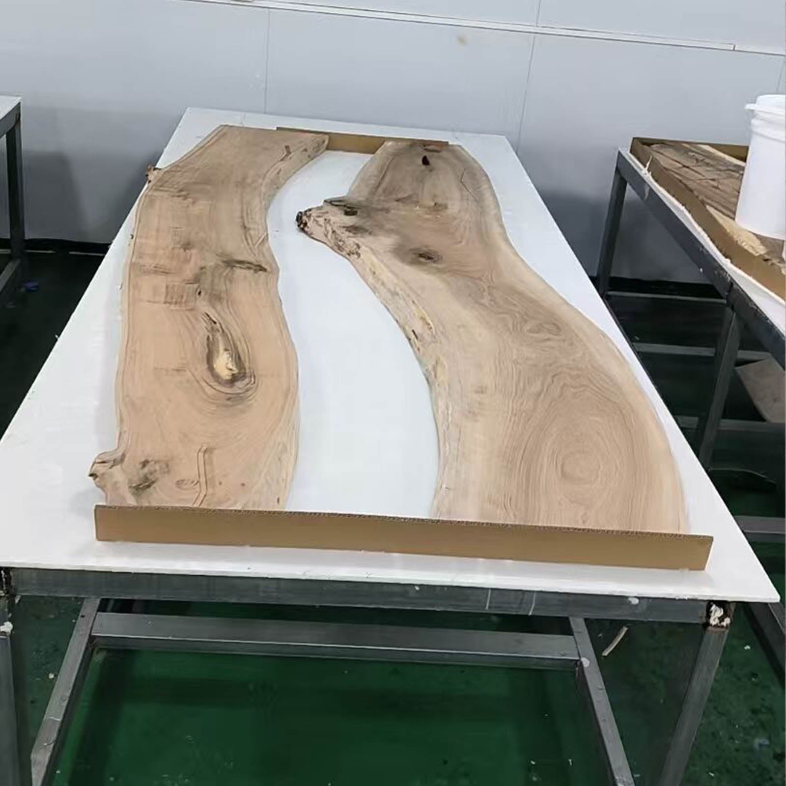 Custom black walnut river table with swirling ocean blue resin and LED lights used as a modern office desk or conference table.