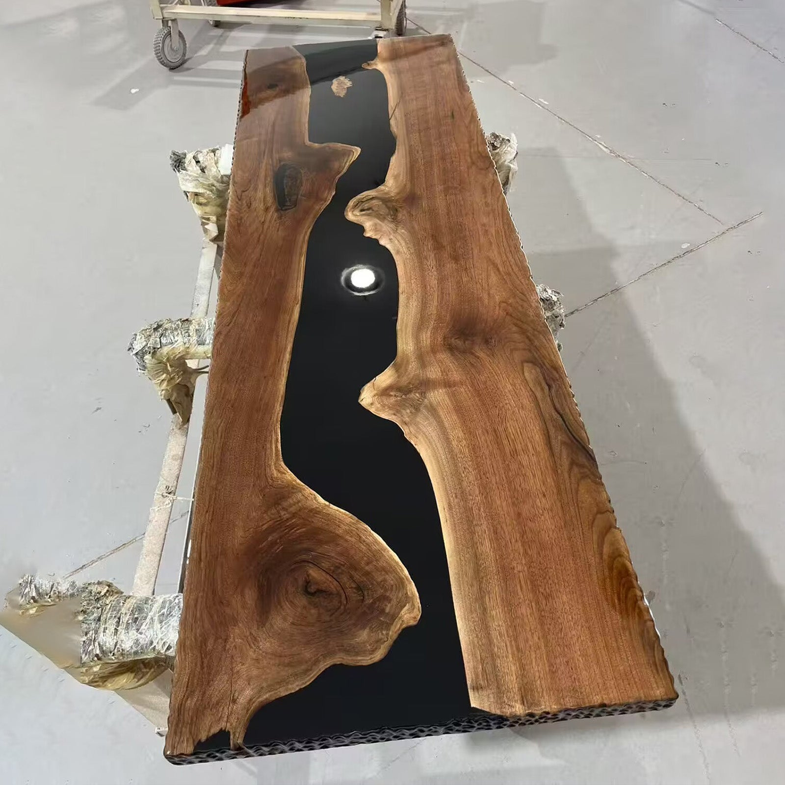 Live edge black walnut table with smooth matte finish and bold black river epoxy center