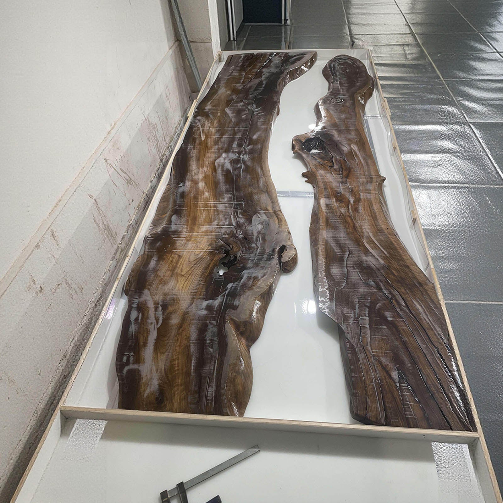 Close-up showing ocean blue resin swirls blending with natural black walnut wood grain.