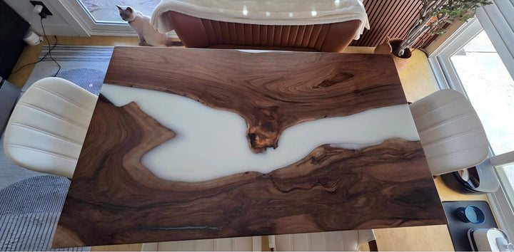Wooden dining table with white resin inlay in a room setting